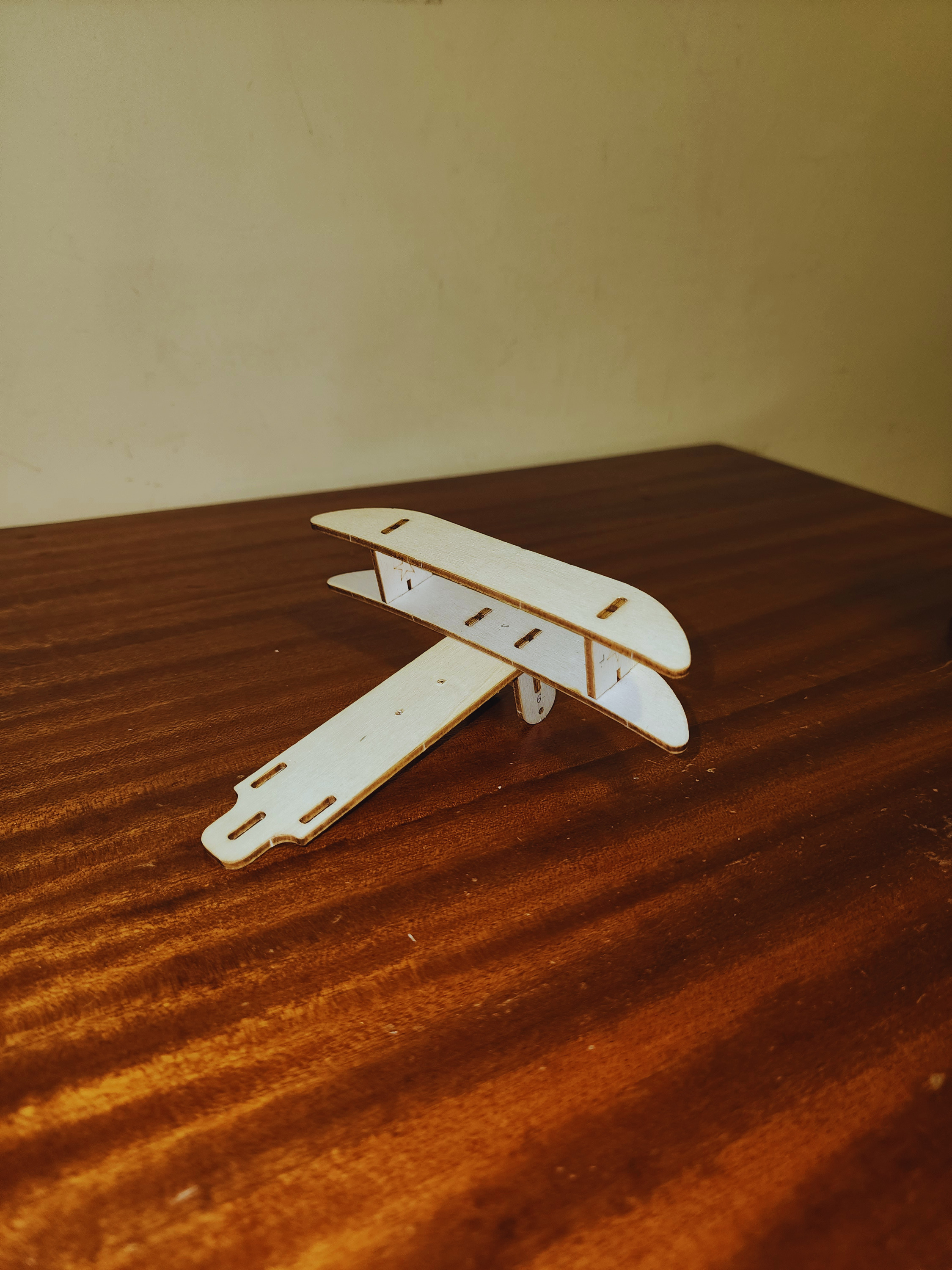 Early assembly stage of the wooden electric biplane kit showing the stacked wing structure and fuselage frame on a workbench.